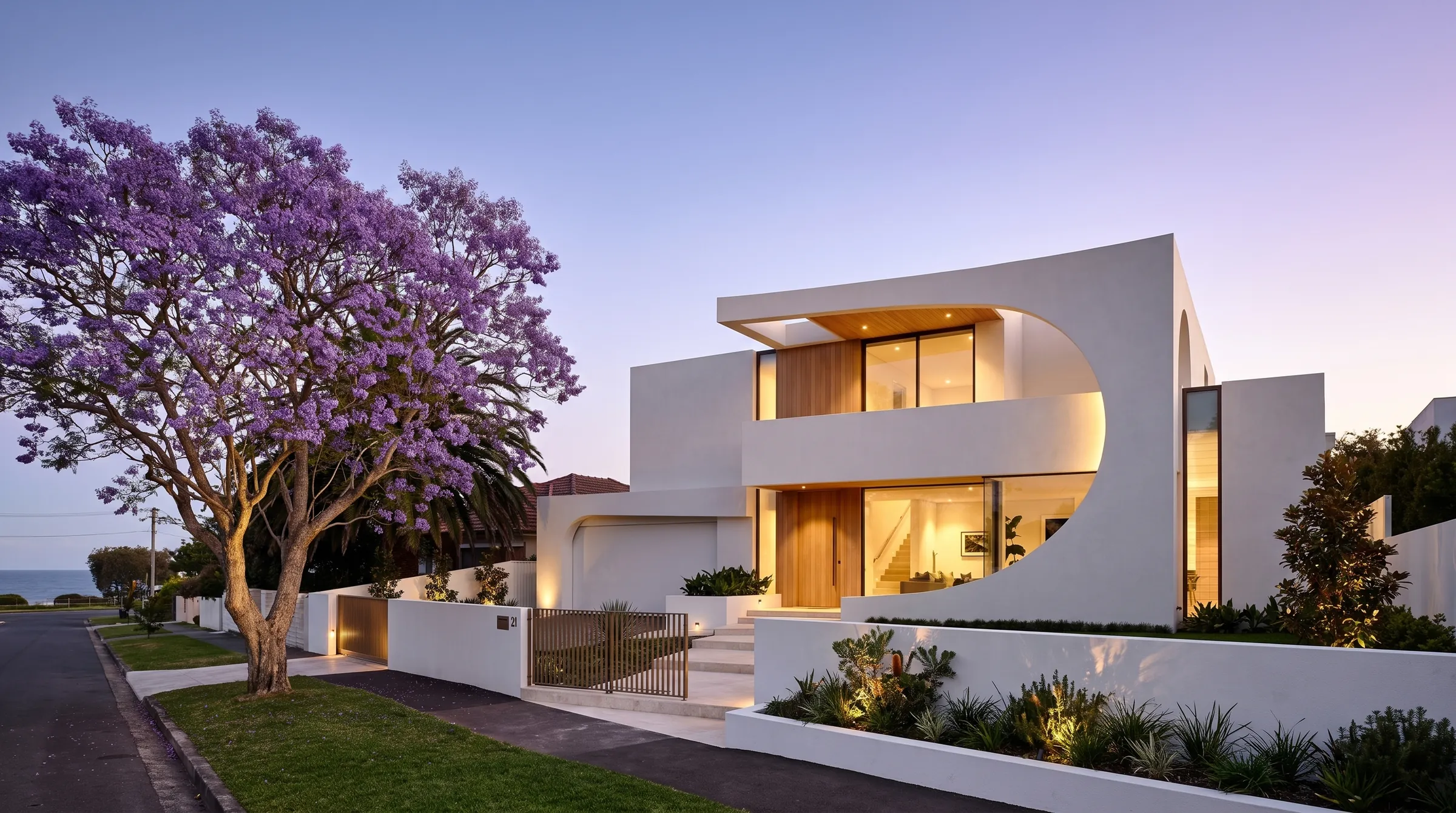 Design visualisation of the street front of the Freshwater Coastal Residence at dusk, with a jacaranda in bloom, low rendered front wall, bronze gates and warm lit interiors